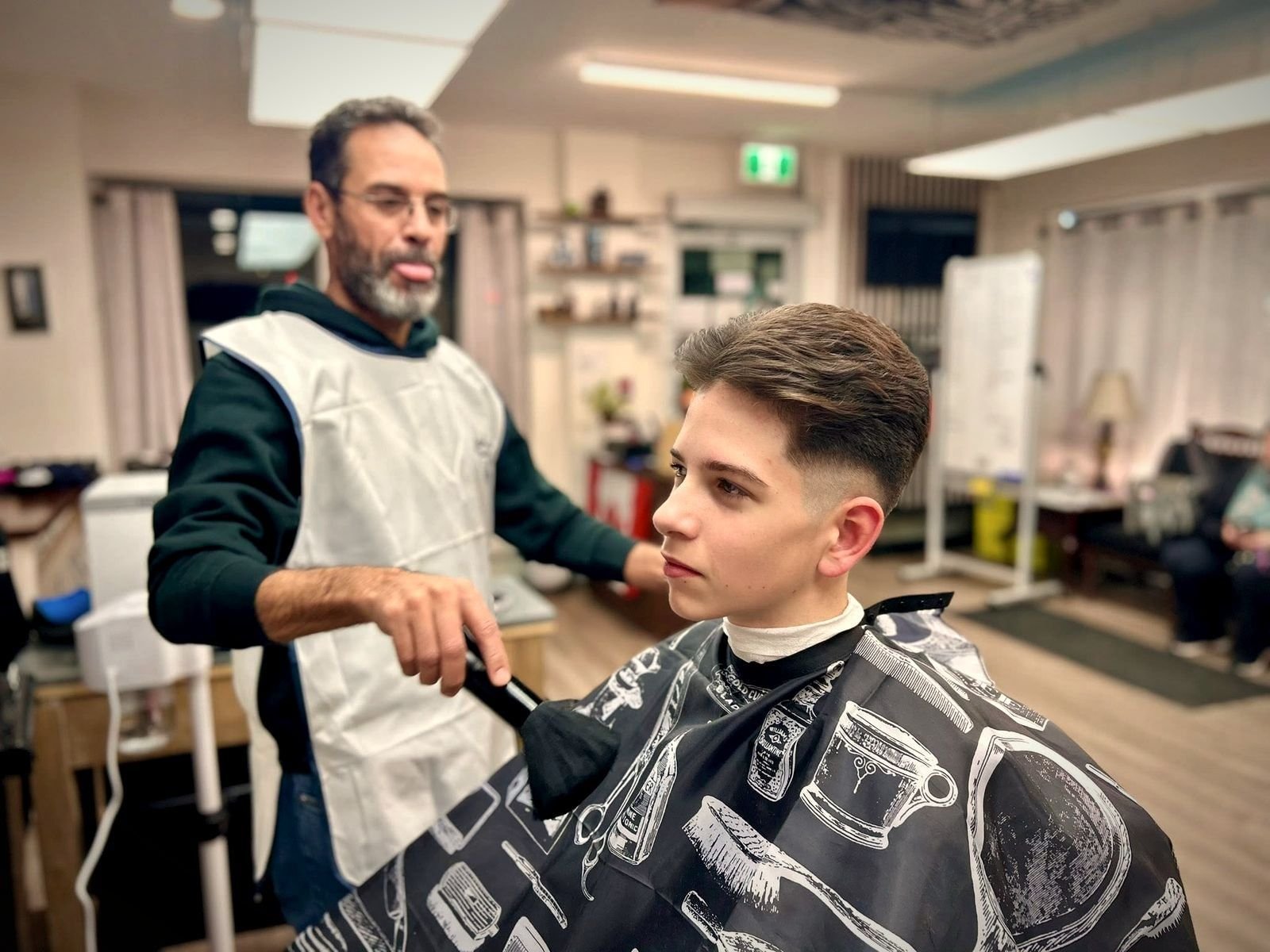 A BC Barber Shop barber blow drying a client's finished cut, BC Barber Shop